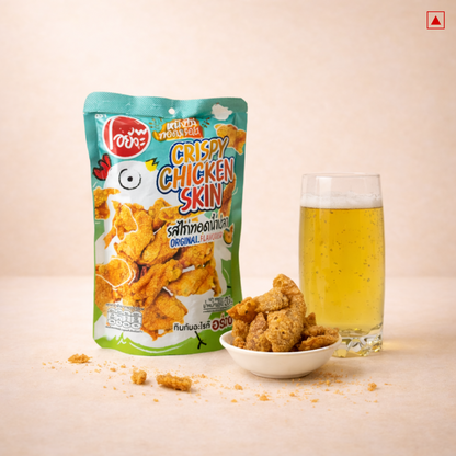 Packaged crispy chicken skin with a glass of beer on a beige background