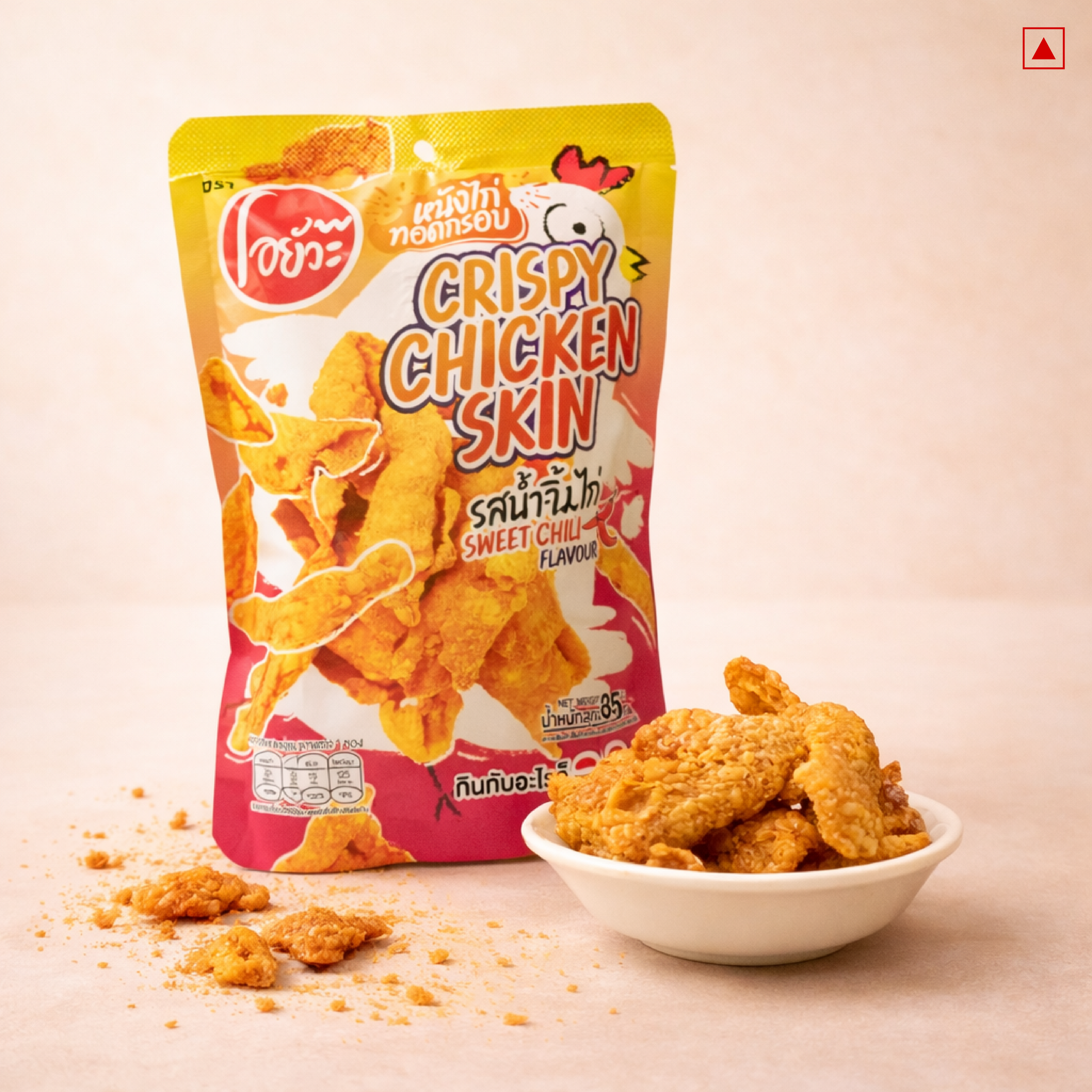 Packaged crispy chicken skin with a bowl of chicken pieces on a beige background