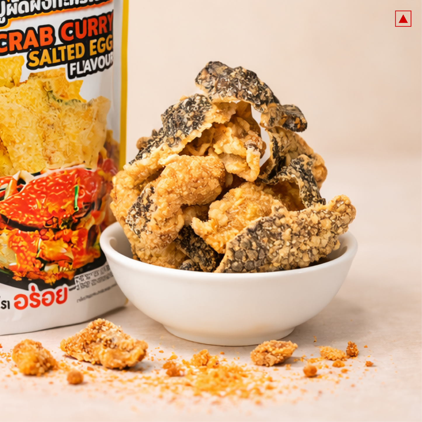 Fried snacks in a bowl with a pack of crab curry salted egg flavor on a beige background
