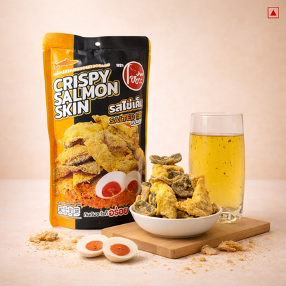 Packaged crispy salmon skin snacks with a bowl and glass of beer on a light background
